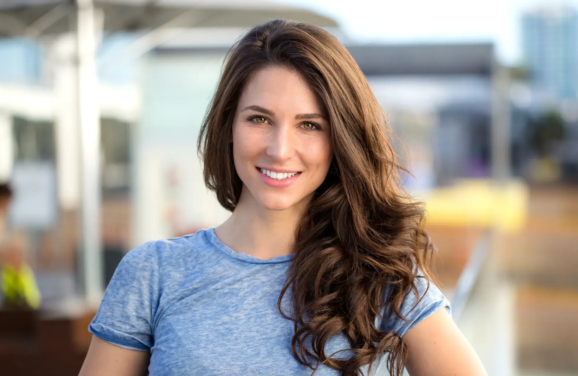 A woman with long brown hair and a blue shirt.