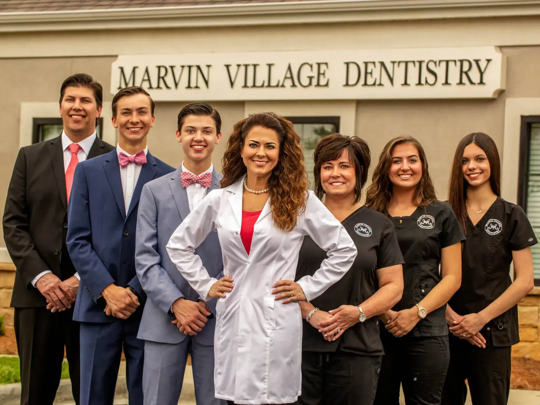A group of people standing in front of a dental office.