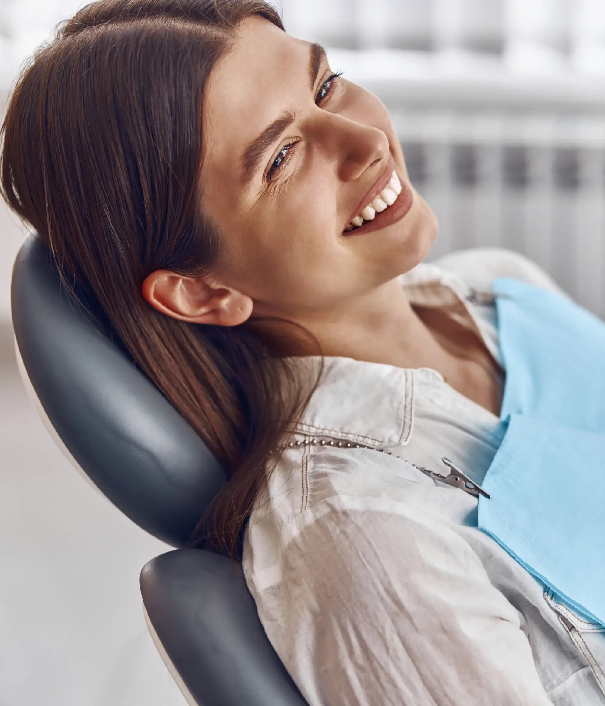 A woman smiling while sitting in a chair.