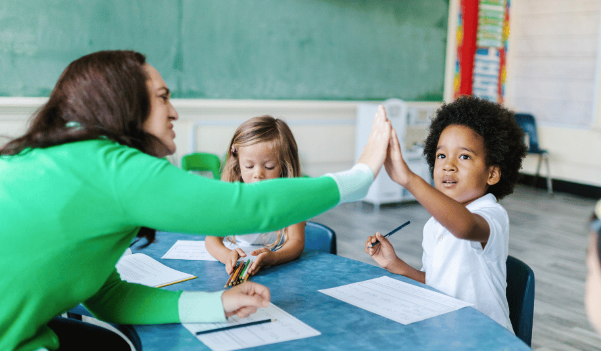 A woman and a young boy look happy, sitting in a classroom