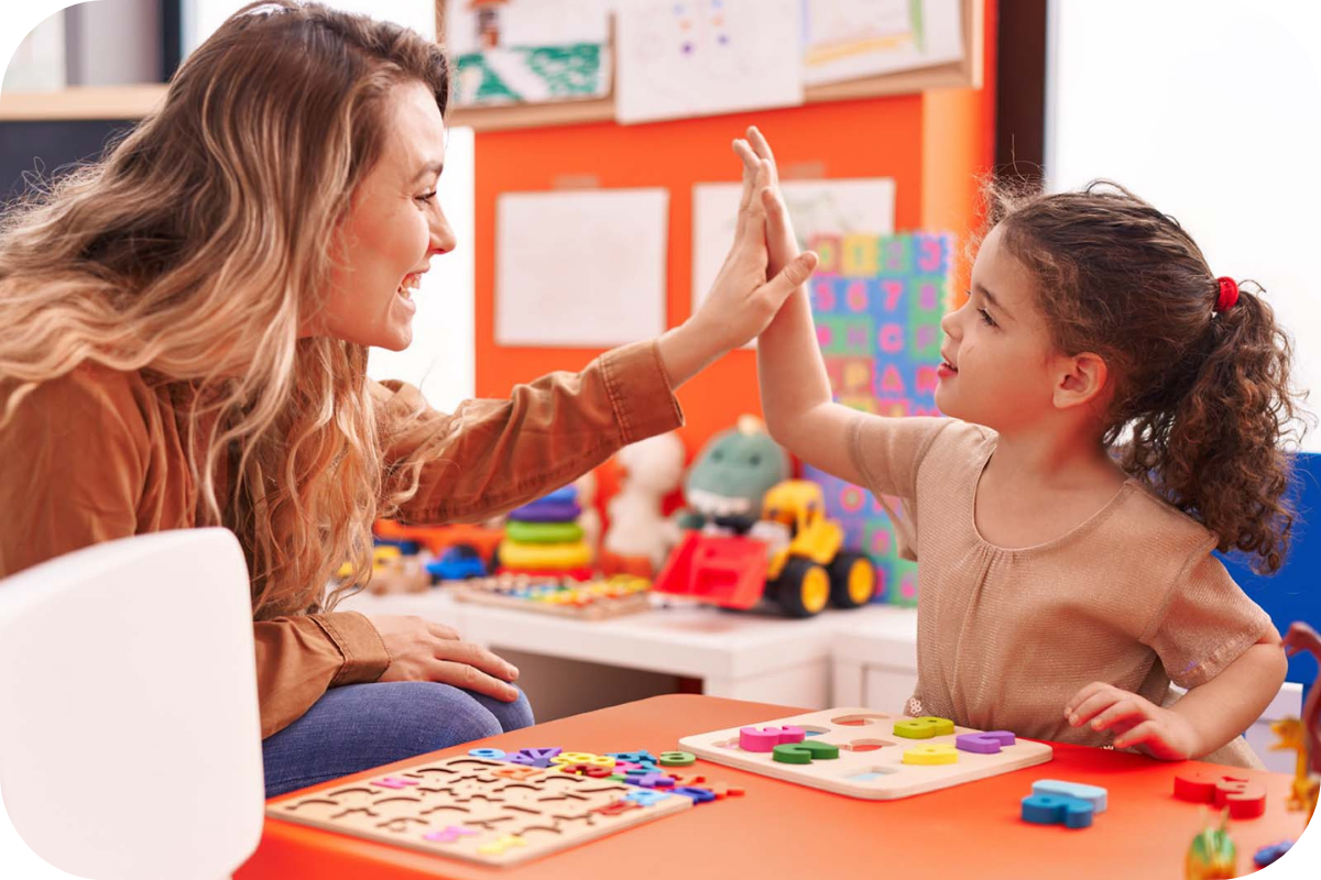 Teacher high fiving a young girl, celebrating sucess