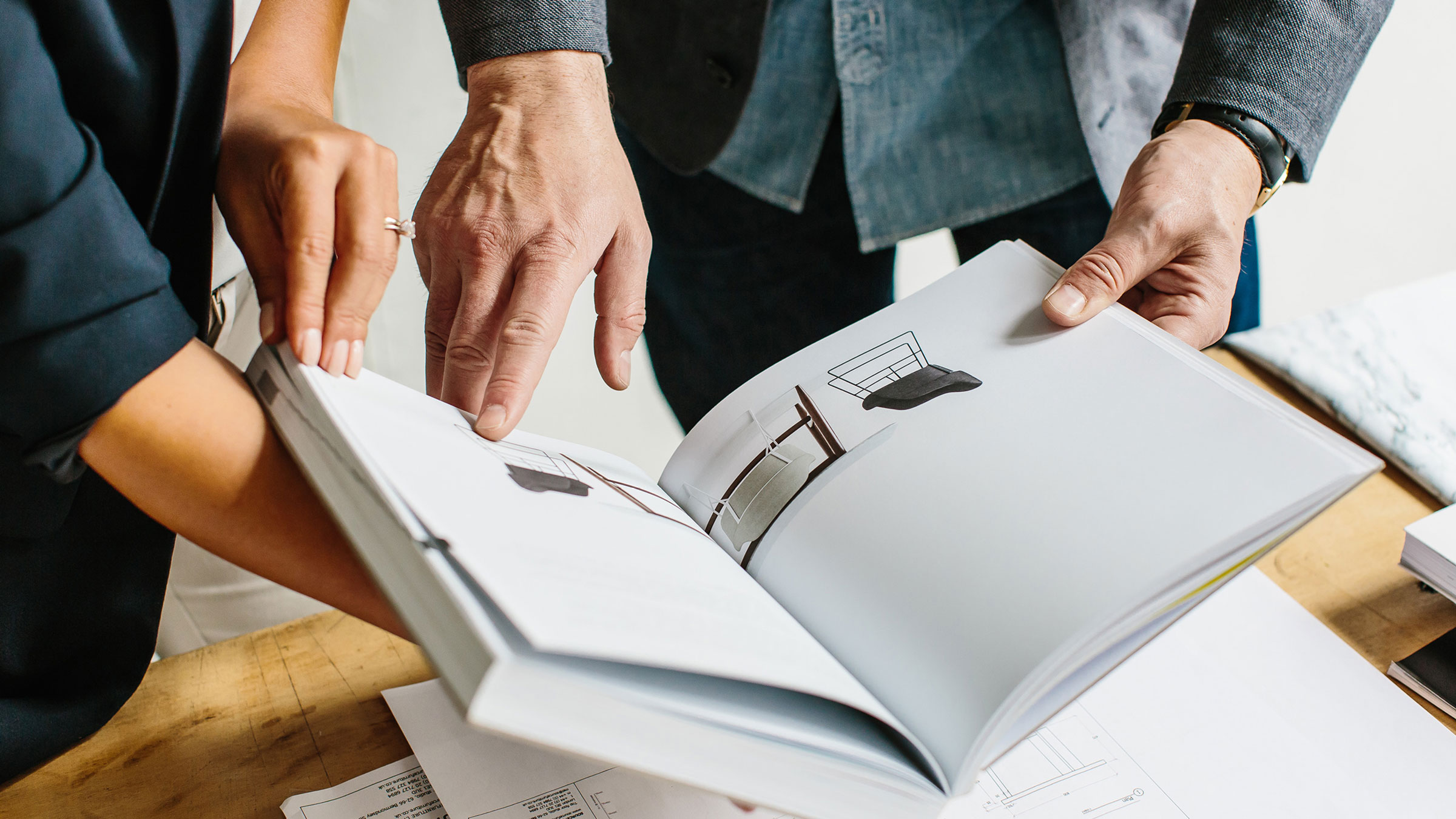 Two people looking through furniture book