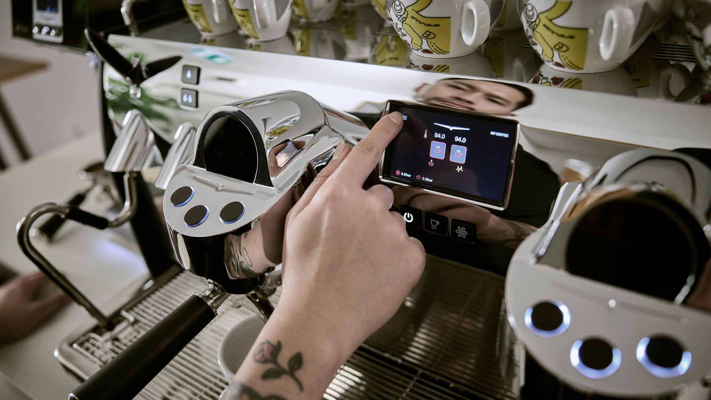 Mikael Jasins hand pressing button on Eagle Core coffee machine