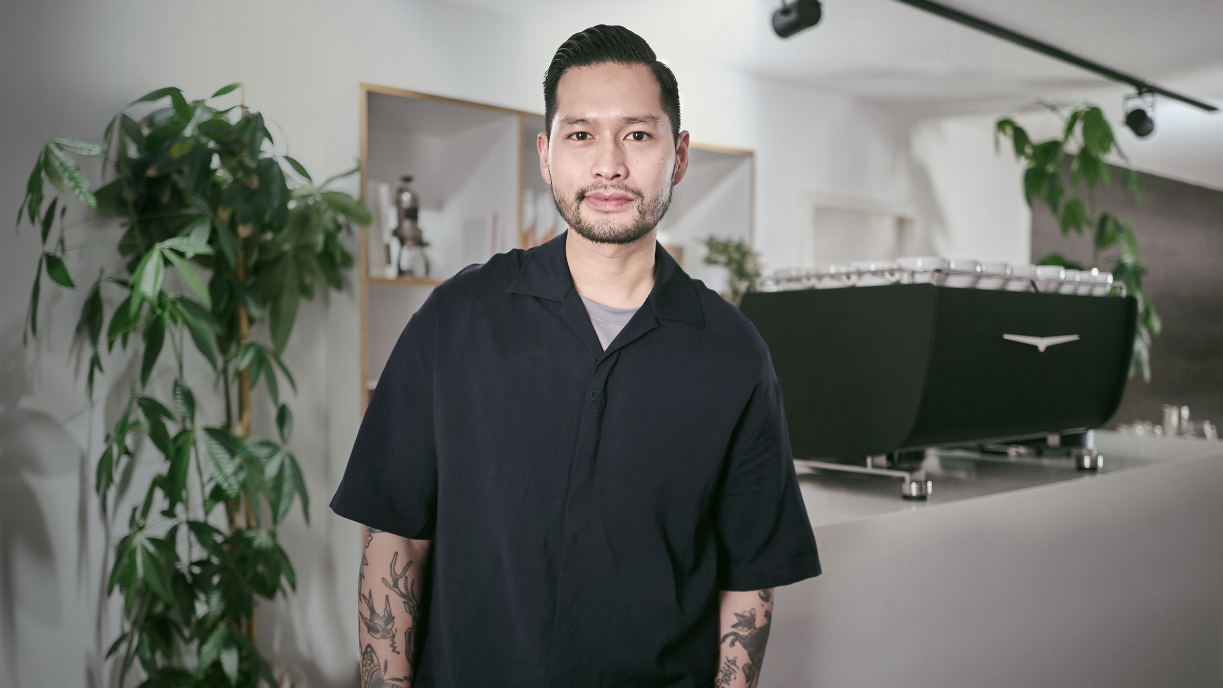 Mikael Jasin standing in front of Eagle Core coffee machine