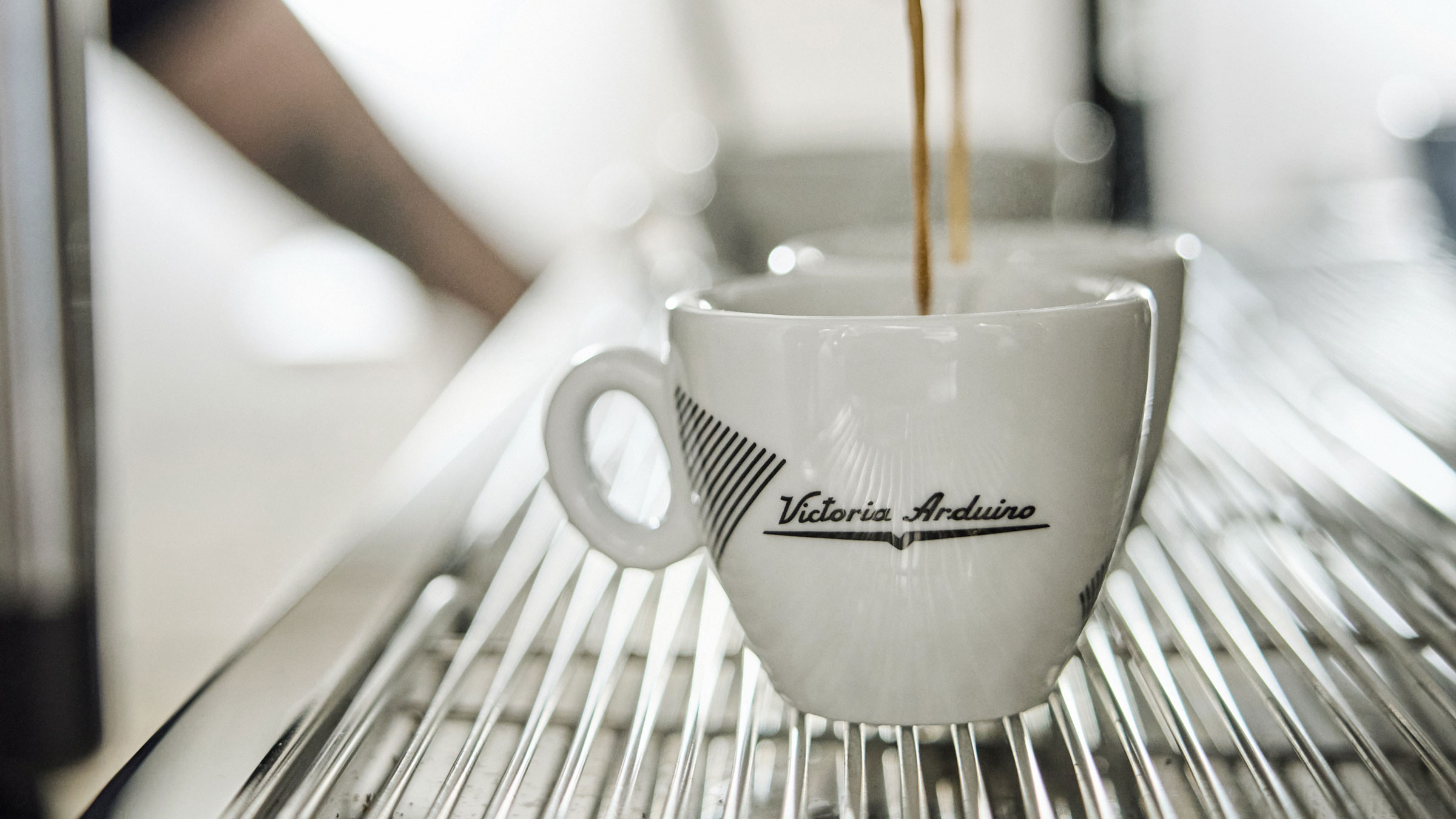 Victoria Arduino espresso cup sat on machine tray with coffee pouring into it