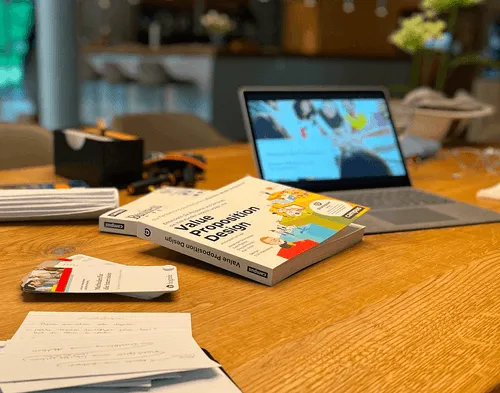 Ein Gesprächstisch mit Laptop und büchern
