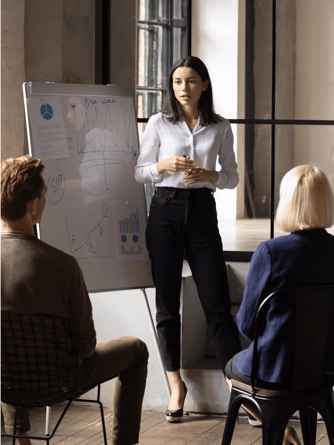 Eine Frau bespricht eine Strategie am Whiteboard

