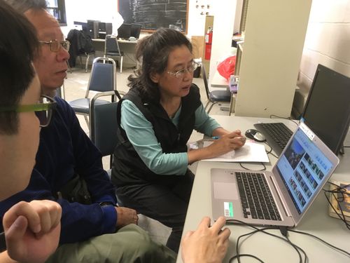 Small group reviewing footage on a laptop during a Third World Newsreel media training session, emphasizing TWN’s distribution-focused educational efforts.