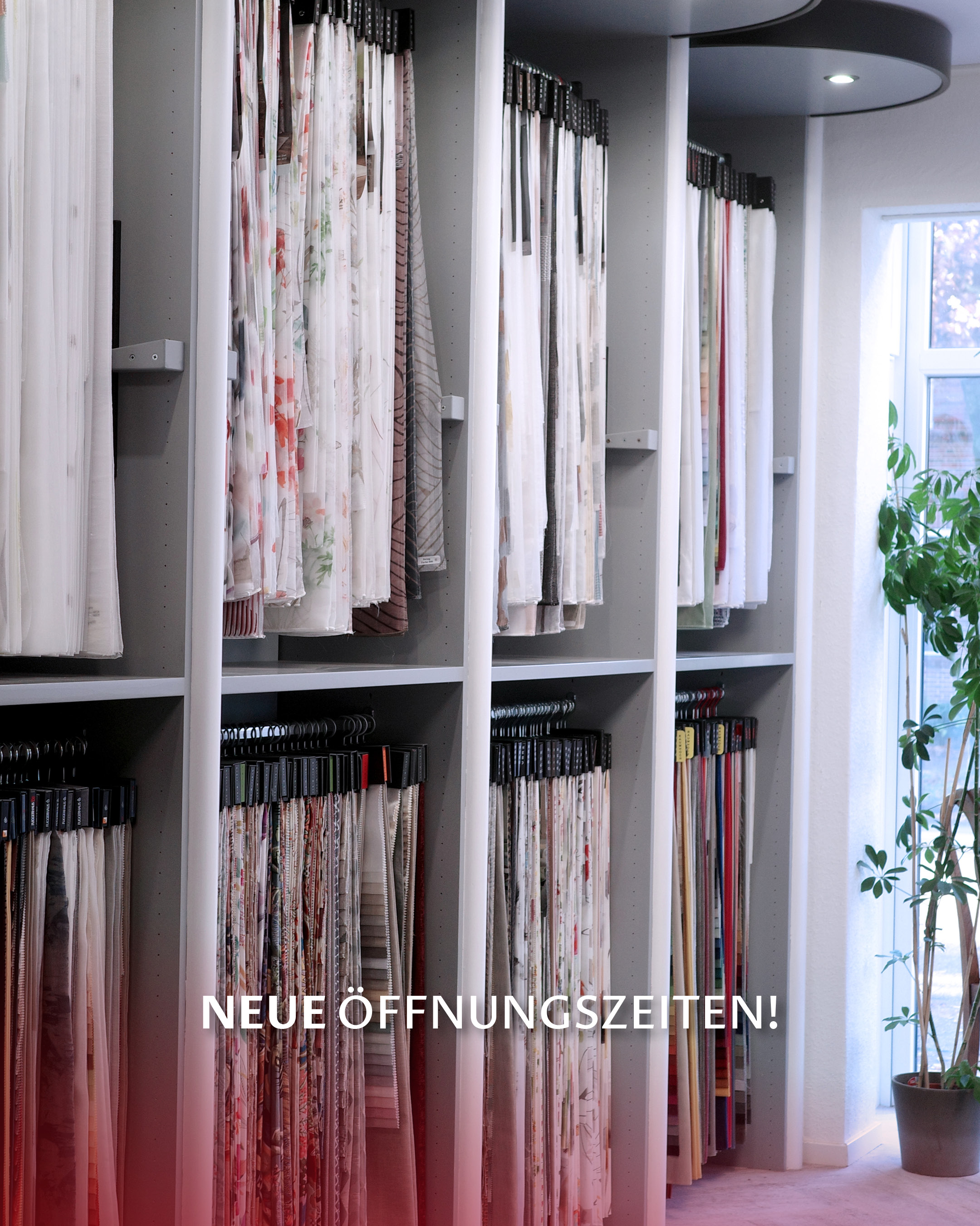 Innenansicht eines stilvoll eingerichteten Raumausstatter-Geschäfts mit Stoffmustern, Wohnaccessoires und einem Schild im Vordergrund, das die neuen Öffnungszeiten ankündigt.