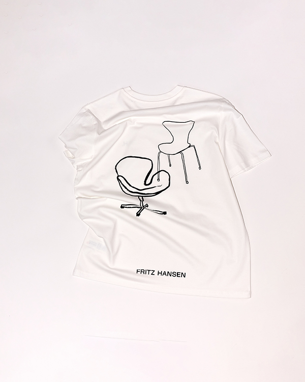 White T-shirt with black line drawings of two chairs and the text 'FRITZ HANSEN' below them.