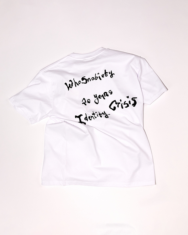 White T-shirt with irregular black text reading 'WhoSnobiety 20 years Identity Crisis' on the back.
