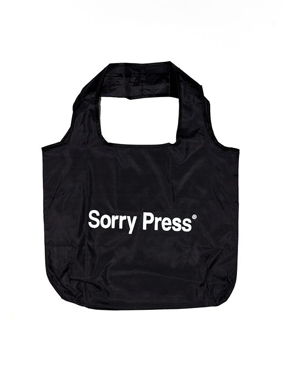 Black reusable tote bag with white text reading 'Sorry Press' on the front.
