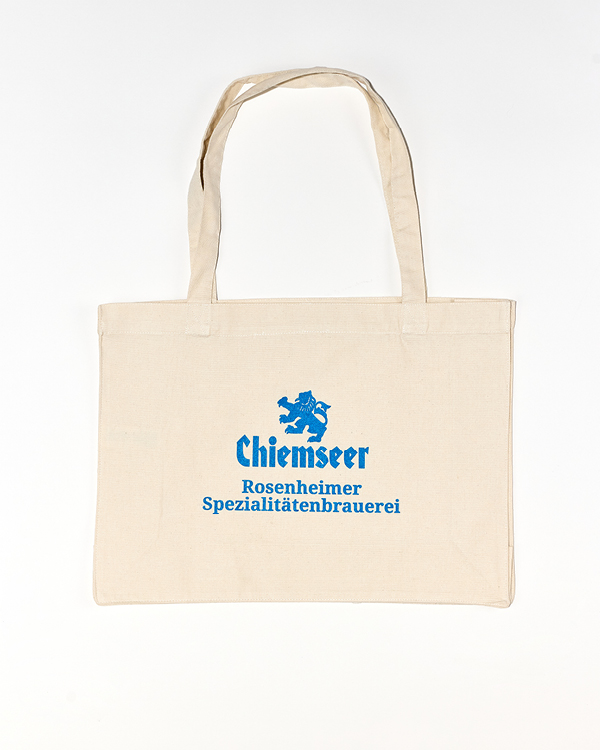 Beige canvas tote bag with blue text and lion logo reading 'Chiemseer Rosenheimer Spezialitätenbrauerei'.