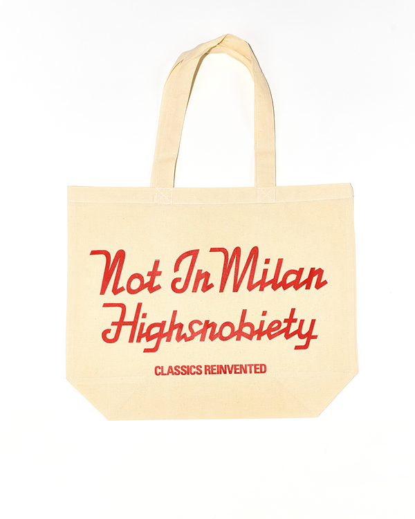 Beige canvas tote bag with red text reading 'Not In Milan Highsnobiety Classics Reinvented'.