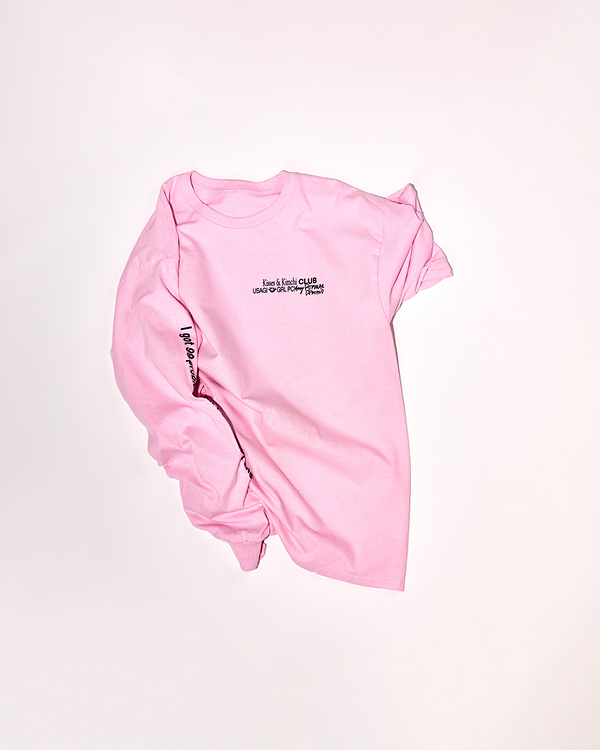 Light pink long-sleeve shirt with small black text logo on chest and black script on left sleeve.