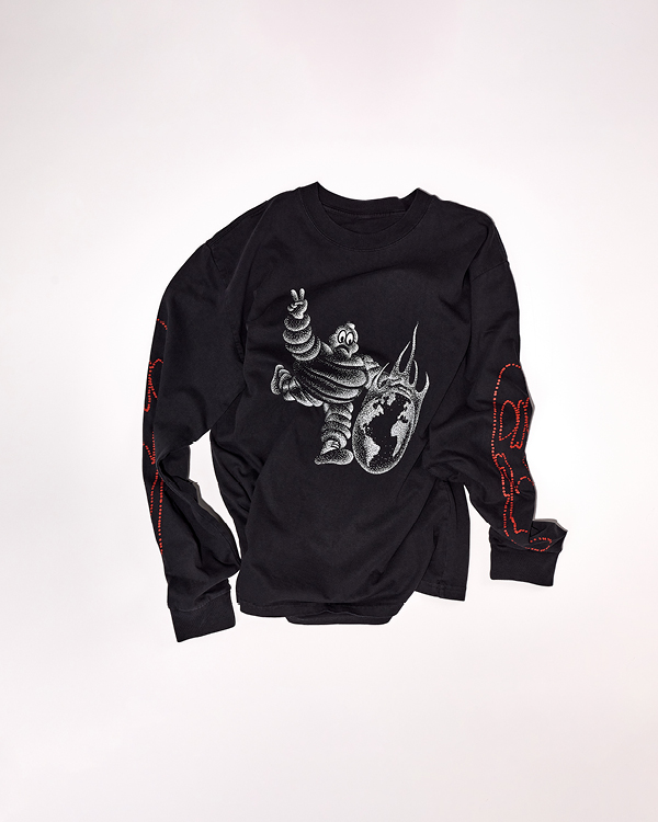 Black long-sleeve shirt with a graphic of a Michelin Man kicking a flaming Earth on the front and red text designs down both sleeves.