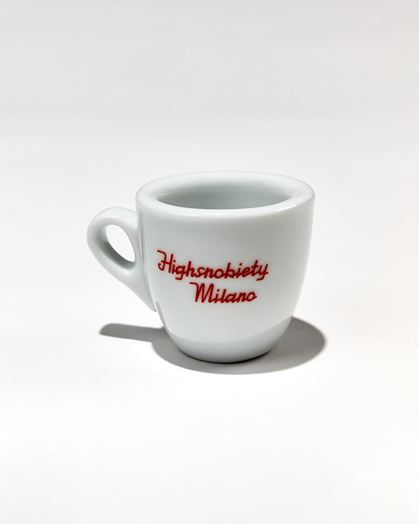 White ceramic espresso cup with the red text 'Highsnobiety Milano' on a white background.
