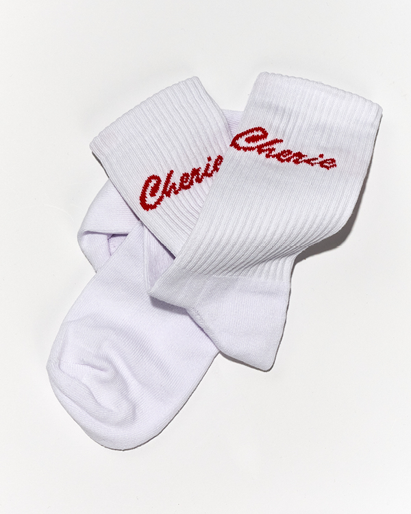 Pair of white ribbed socks with the word 'Cherie' knitted in red cursive near the cuff.