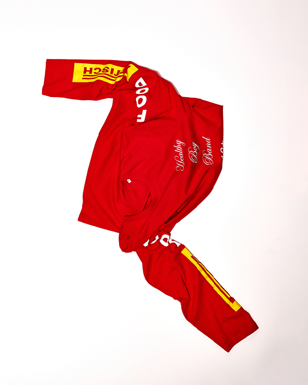 Red long-sleeve shirt with white text saying 'Healthy Body Brand' on the front and yellow patches with red text on the sleeves.