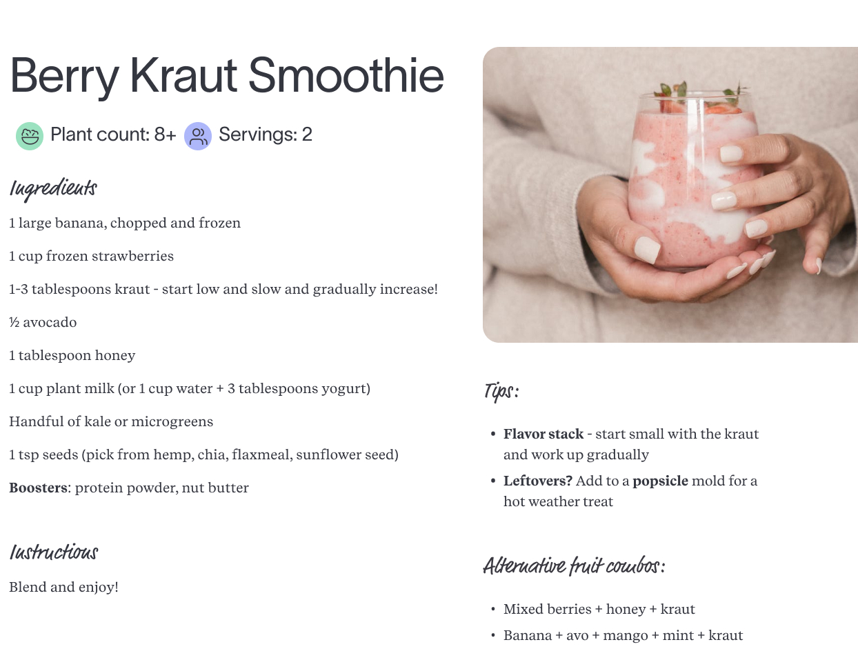 Berry kraut smoothie recipe shown in a glass with banana, strawberries, kraut, and seeds, held in both hands.