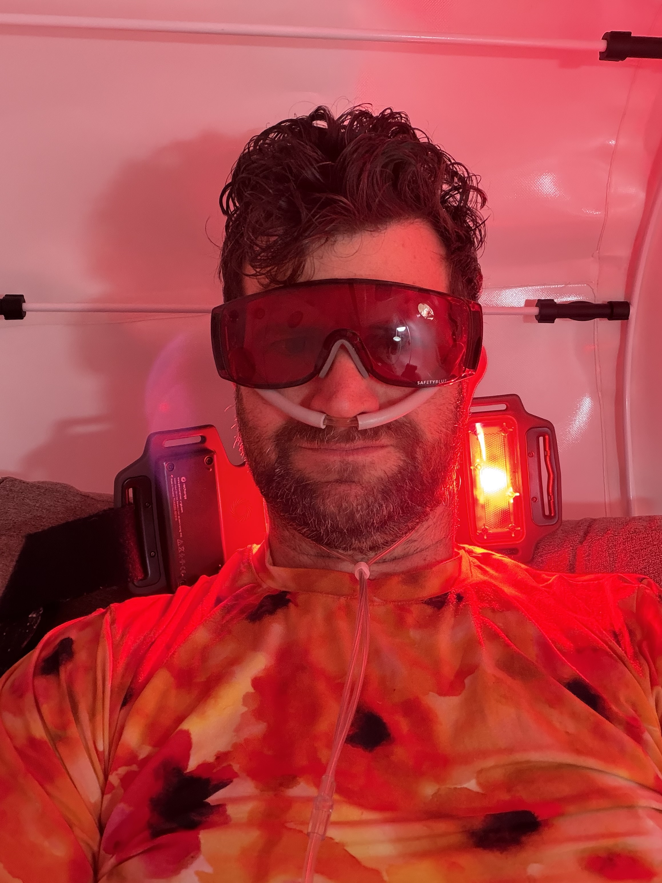 Joe, with googles, does regular sessions of hyperbaric oxygen therapy with red light therapy.