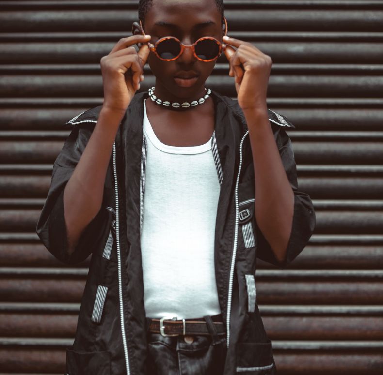 Stylish man with wearing a black shirt putting on sunglasses