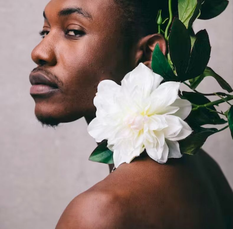 A close up shot of a man with a flower on his neck