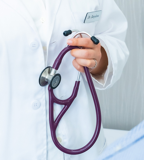 Doctor wearing a white coat holding a purple stethoscope with a name tag that reads Dr. Douglas.
