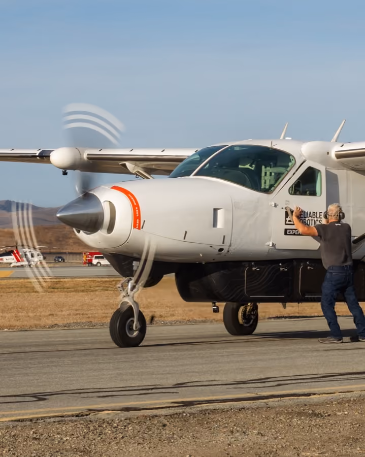 A Reliable Robotics Cessna Caravan on the ramp with an engineer alongside
