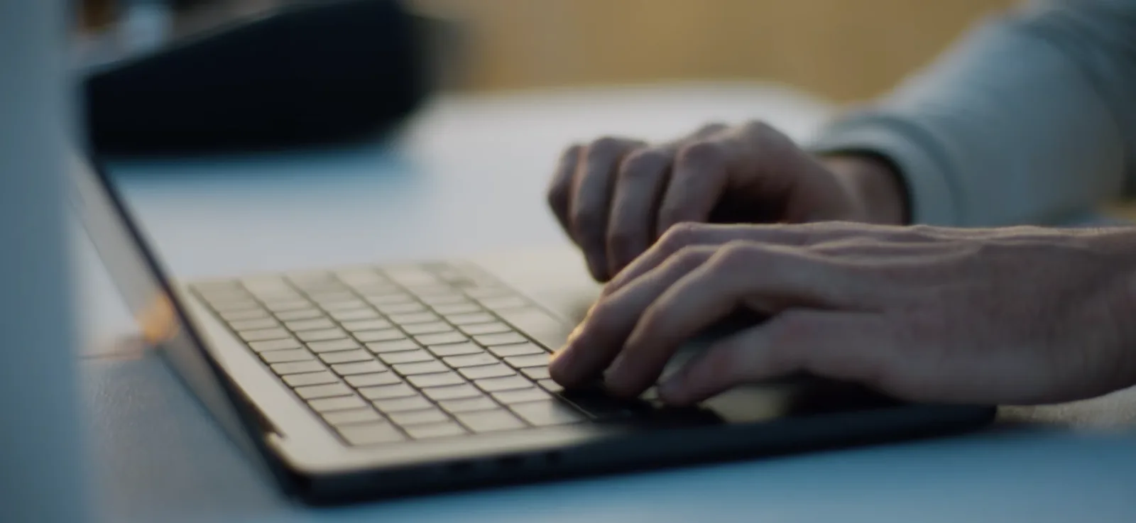 Hands typing on a laptop keyboard