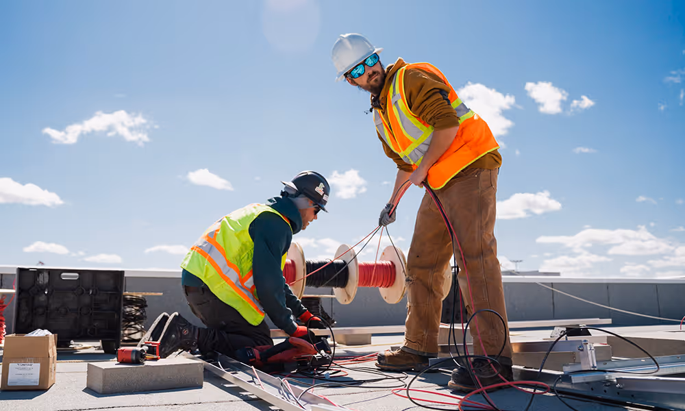 Engineers installing a complicated solar array on a roof
