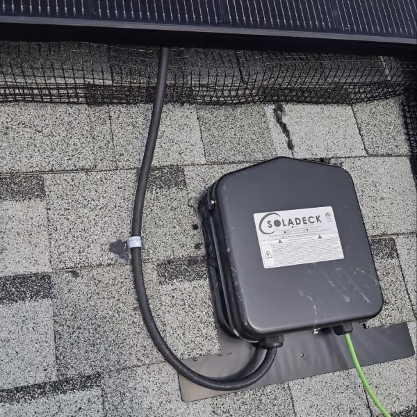 Poorly installed SolaDeck junction box with unsupported electrical cable and inadequate roof attachment