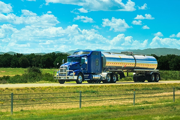 Tanker truck driving down road.