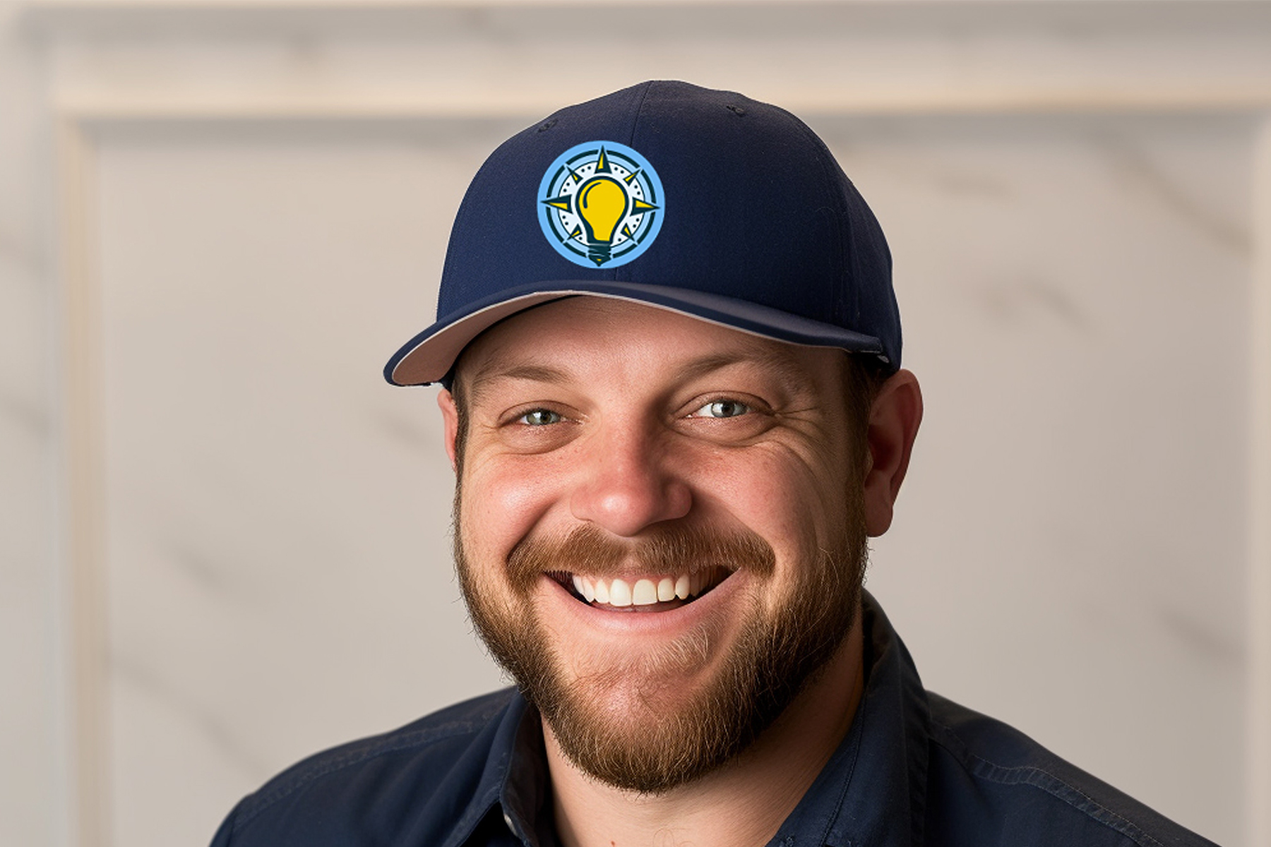 A smiling electrician wearing a ROAM baseball cap.
