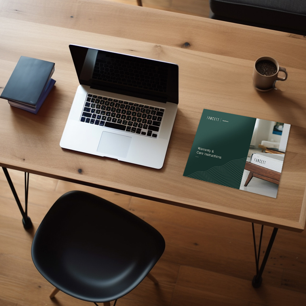 An overhead view of a desktop including a Fawcett brochure and a laptop computer.