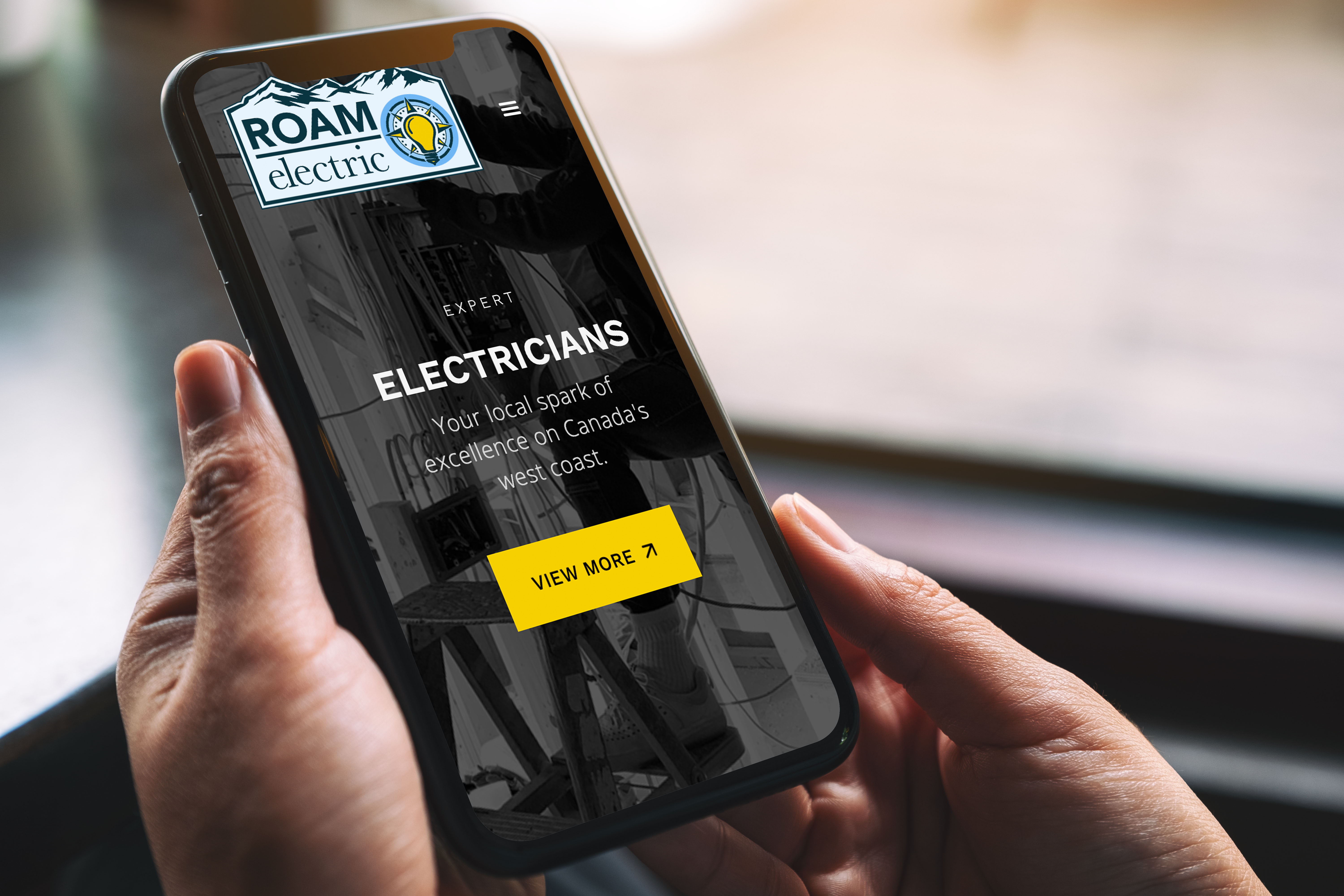 A smartphone featuring a mobile version of ROAM's website.