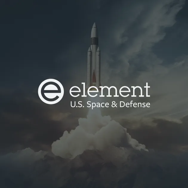 Rocket launching above mountains with clouds and sky, overlayed with Element U.S. Space & Defense logo.