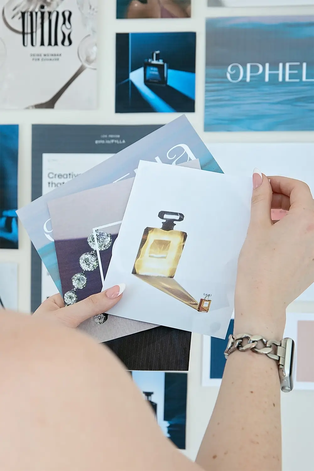 Various brand imagery being held next to a mood board wall.