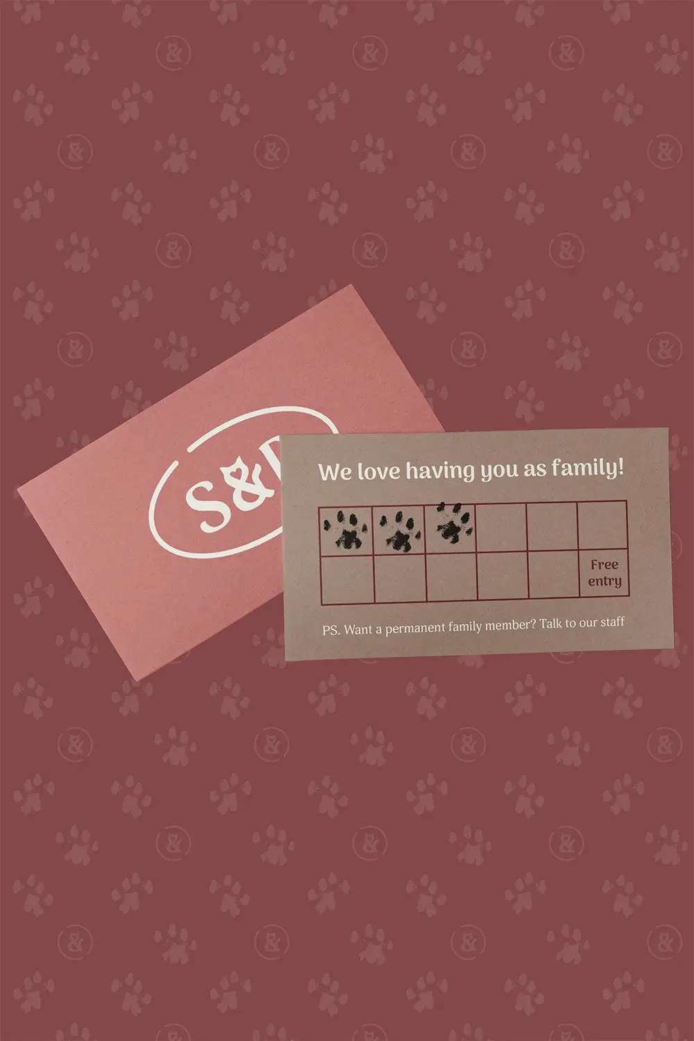 Sip & Purr Cat Café pink and brown loyalty card design with paw prints for stamps. Darker pink brand pattern of paw prints and brand mark in the background.