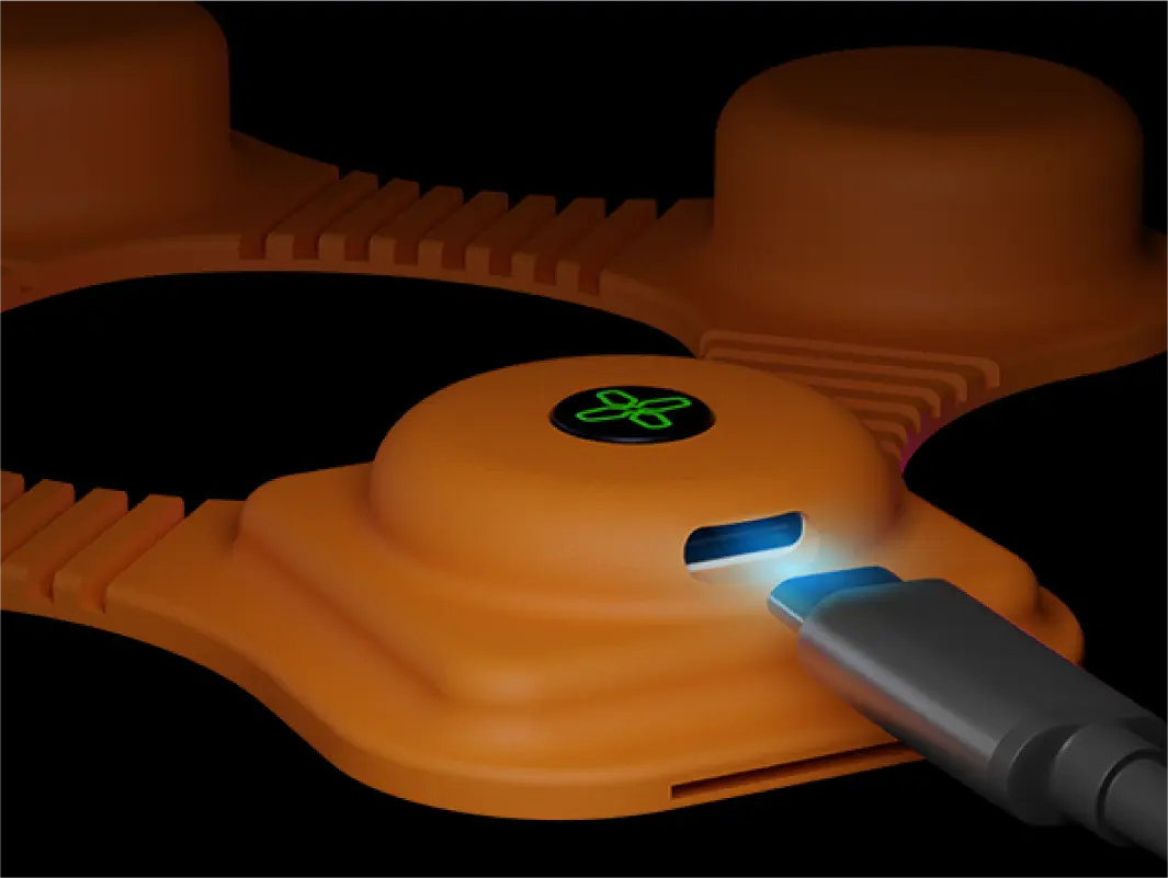 3D model render of orange electronic device with a glowing green symbol being connected to a USB-C cable on a black background.