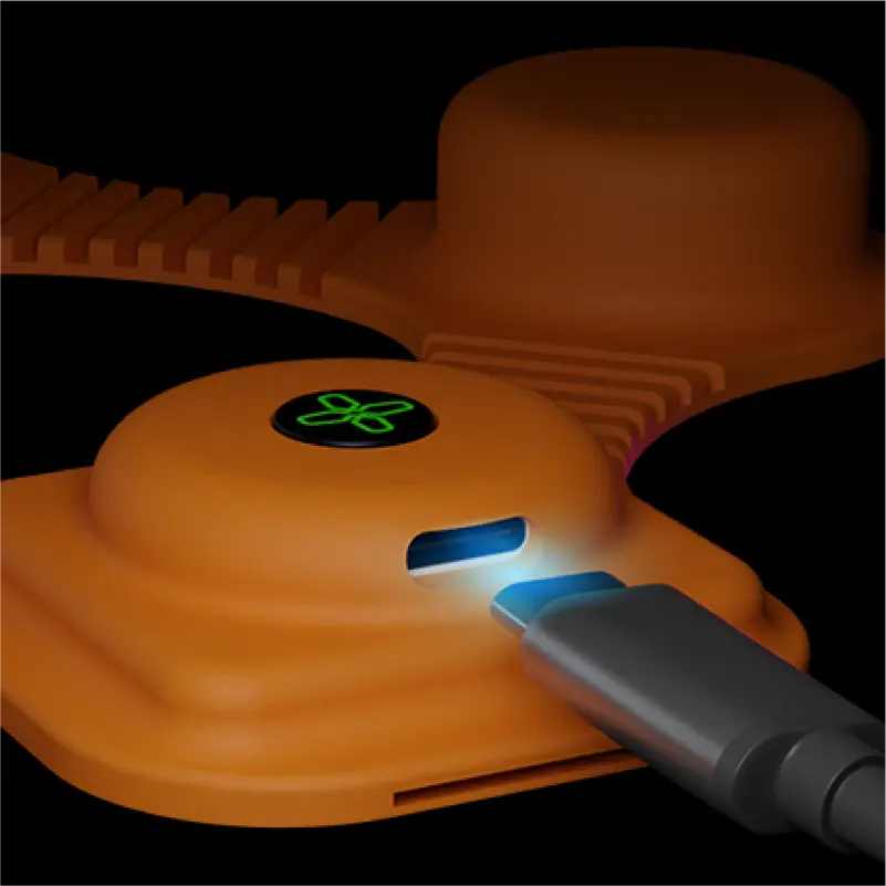 3D model render of orange electronic device with a glowing green symbol being connected to a USB-C cable on a black background.
