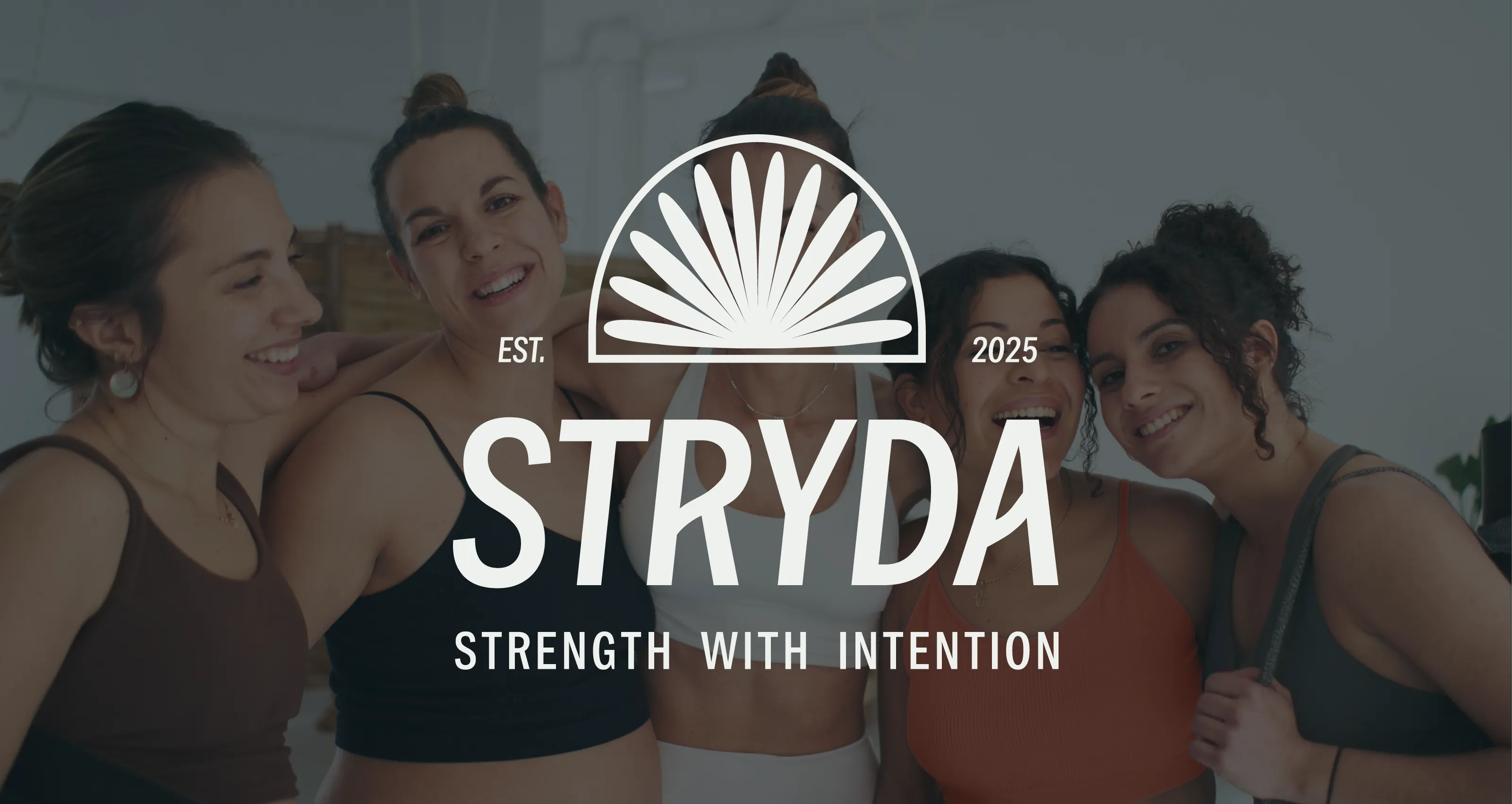 Five women in athletic wear smiling and posing together with STRYDA gym brand logo and slogan 'Strength with Intention' overlay.