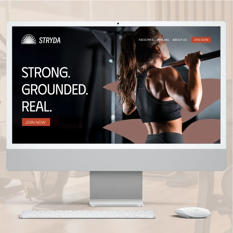 Computer screen displaying STRYDA gym website design with a muscular woman doing pull-ups with a brand asset behind her, and text saying 'STRONG. GROUNDED. REAL.'