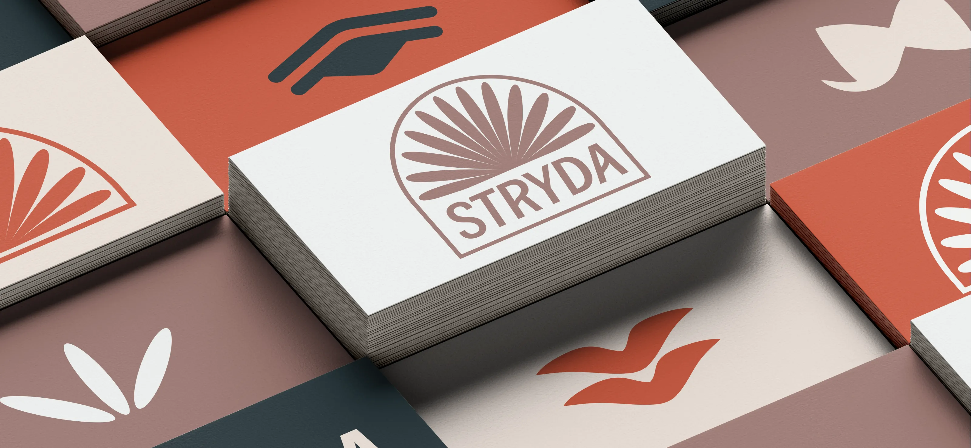 Stack of rectangular cards with the STRYDA logo featuring a stylized New Zealand Falcon's tail design in brown tones and various branded icons on other cards in warm brand colours.