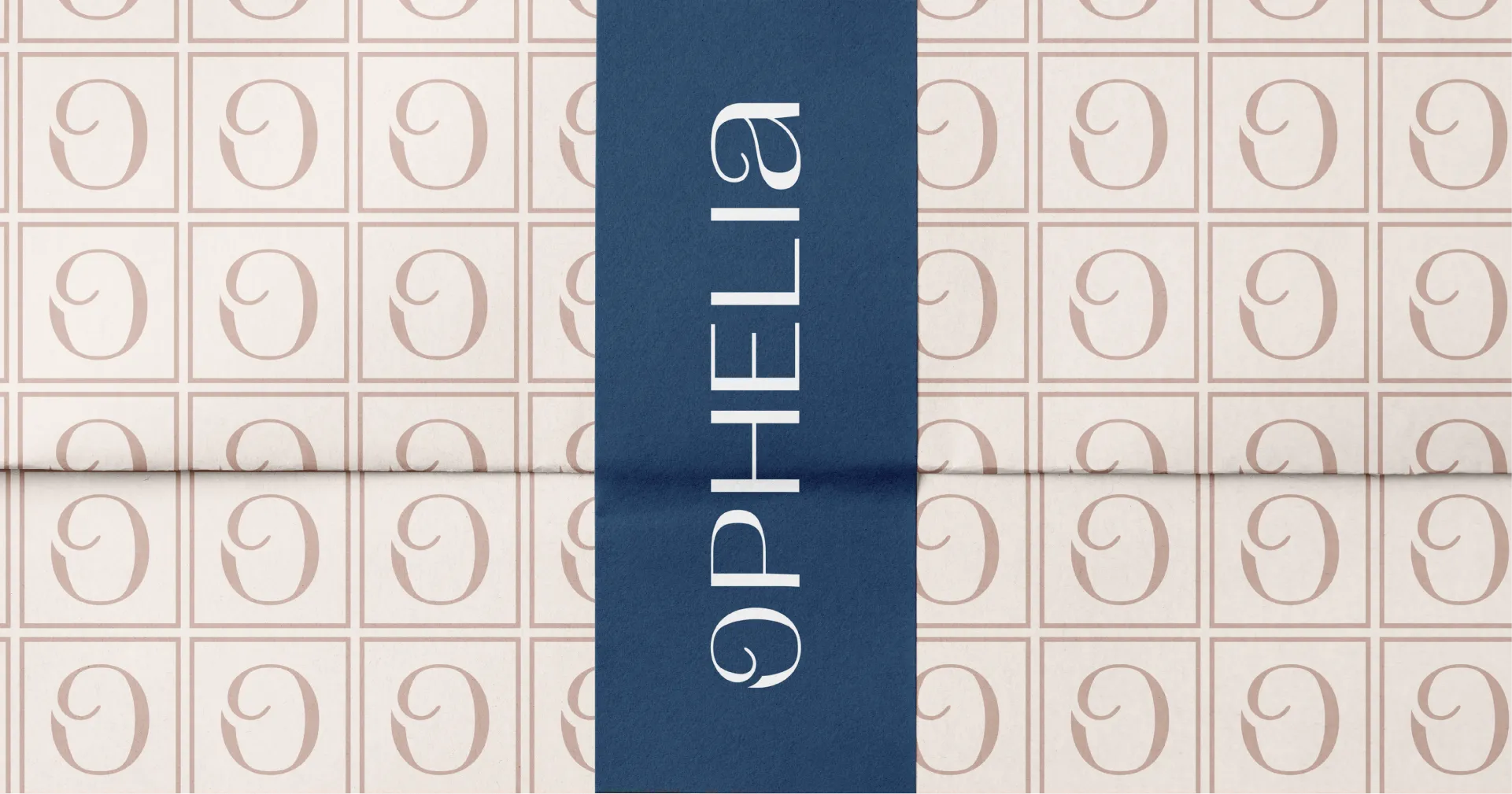 Blue vertical tape with the logo wordmark OPHELIA in white over a beige background tiled wrapping paper with a stylized letter O inside squares repeating pattern.