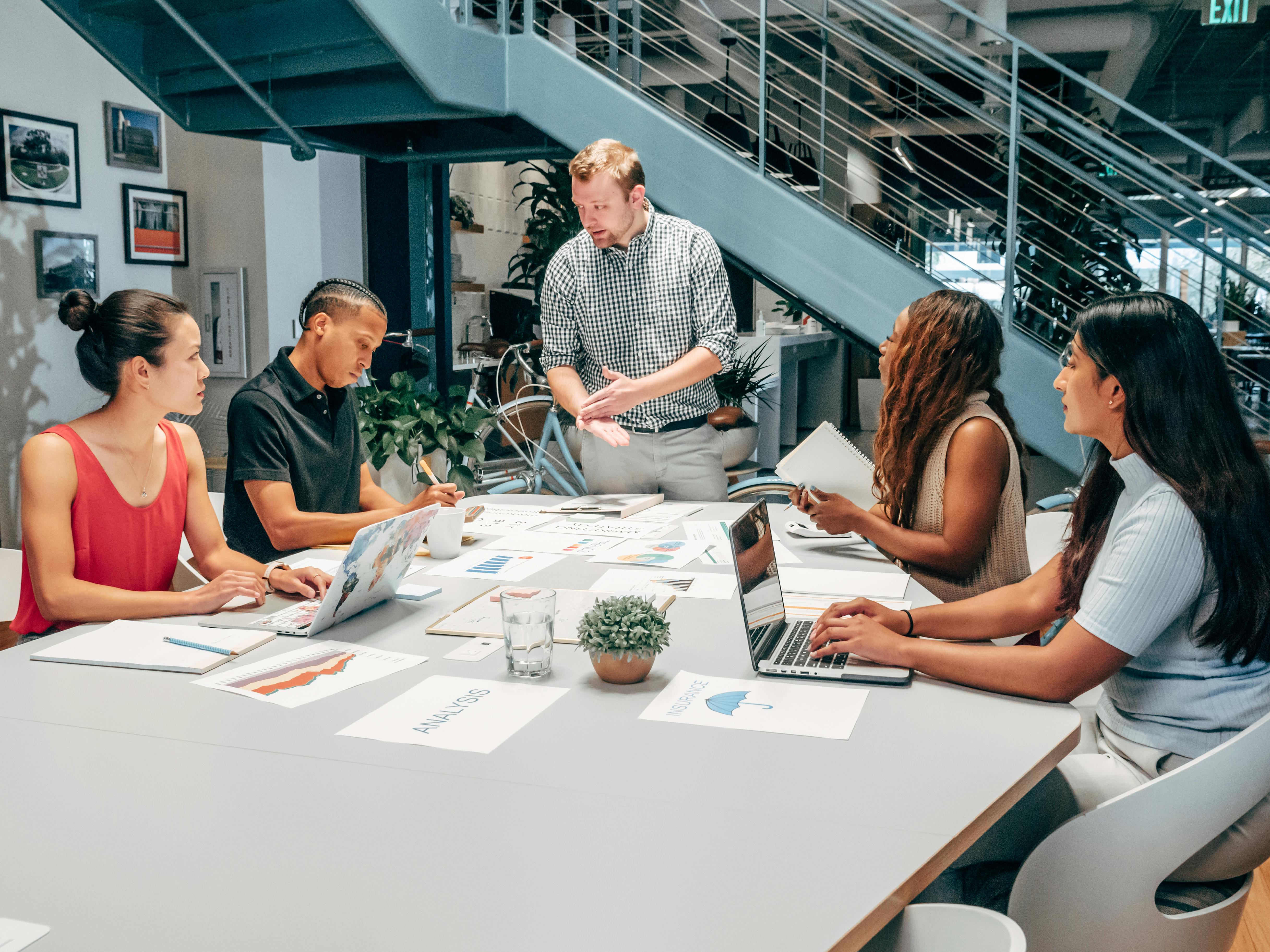 Group of diverse business professionals having a discussion in a modern office, illustrating fractional sales leadership in action, supporting scalable growth without full-time overhead.