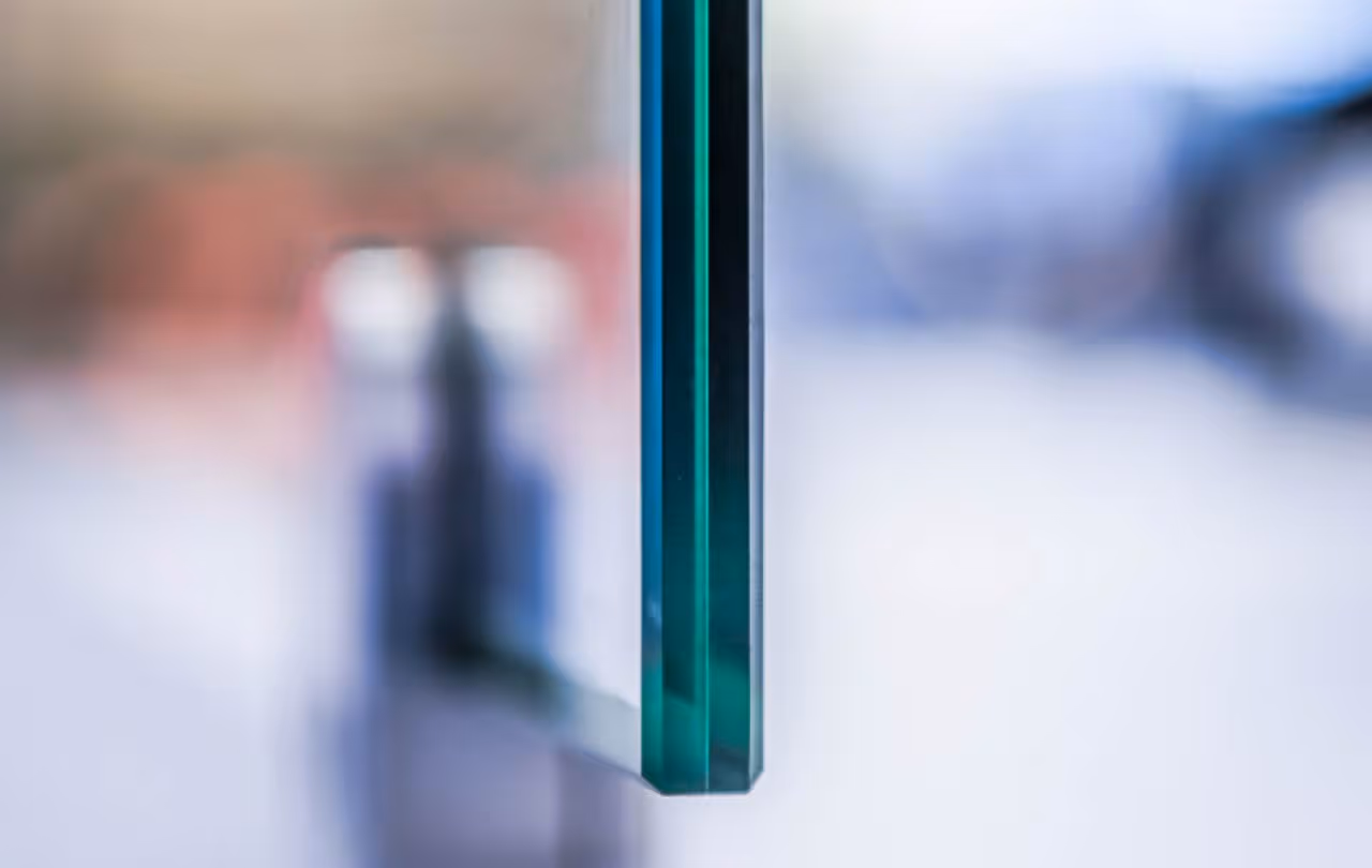 Close-up of two parallel glass panes with a blurred background.
