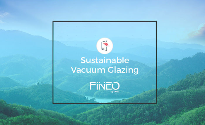 Mountains with green forest under blue sky behind a box reading Sustainable Vacuum Glazing Fineo by AGC.