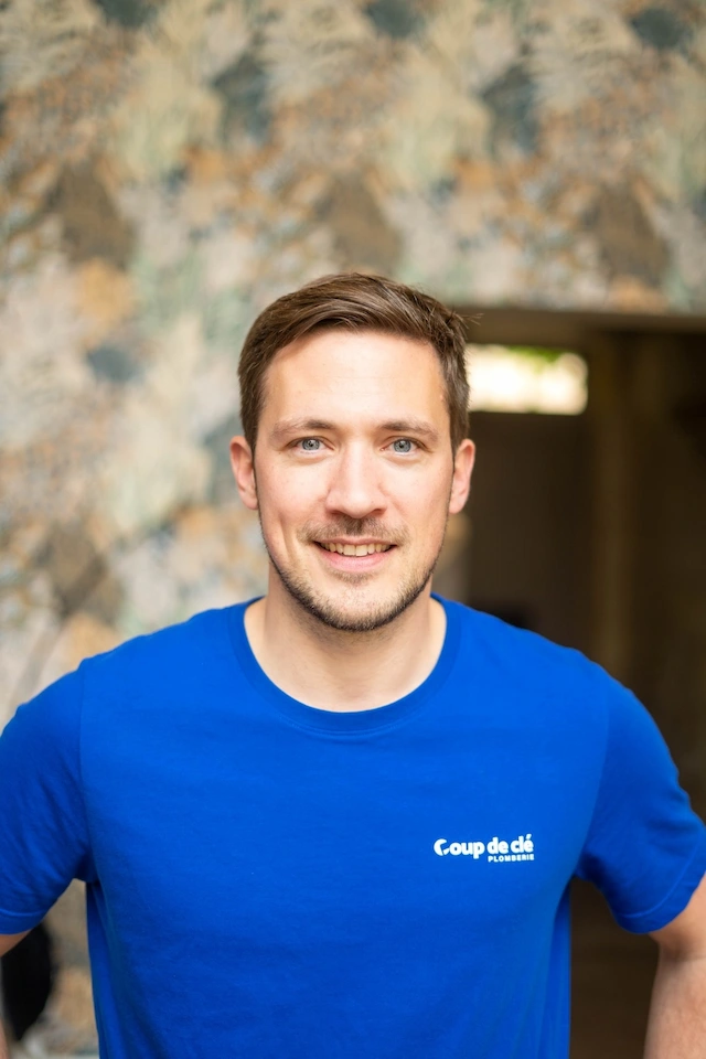 Alex Valette, membre de l’équipe Coup de clé, souriant en t-shirt bleu avec le logo de l’entreprise