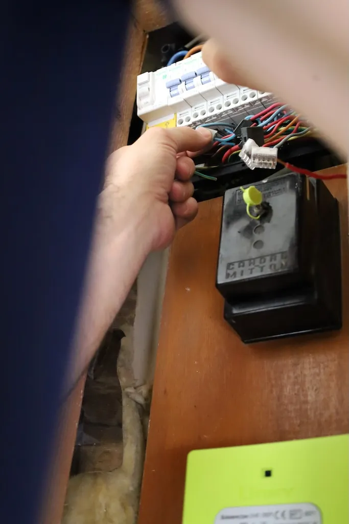 Technicien Coup de clé manipulant des fils électriques pour diagnostiquer des câbles endommagés dans un tableau bordelais